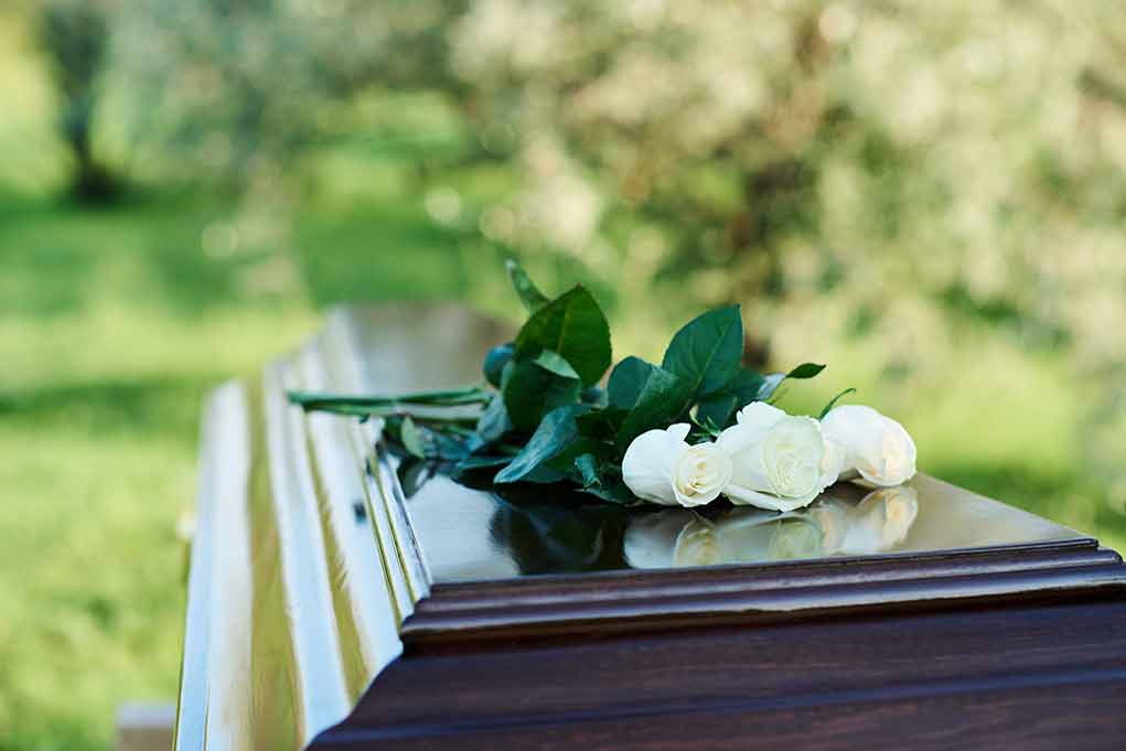 White roses on a wooden casket.