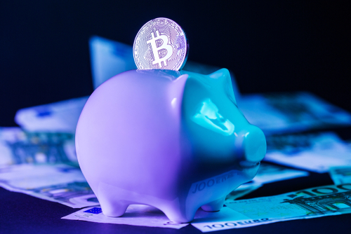 Piggy bank with Bitcoin and dollar bills.