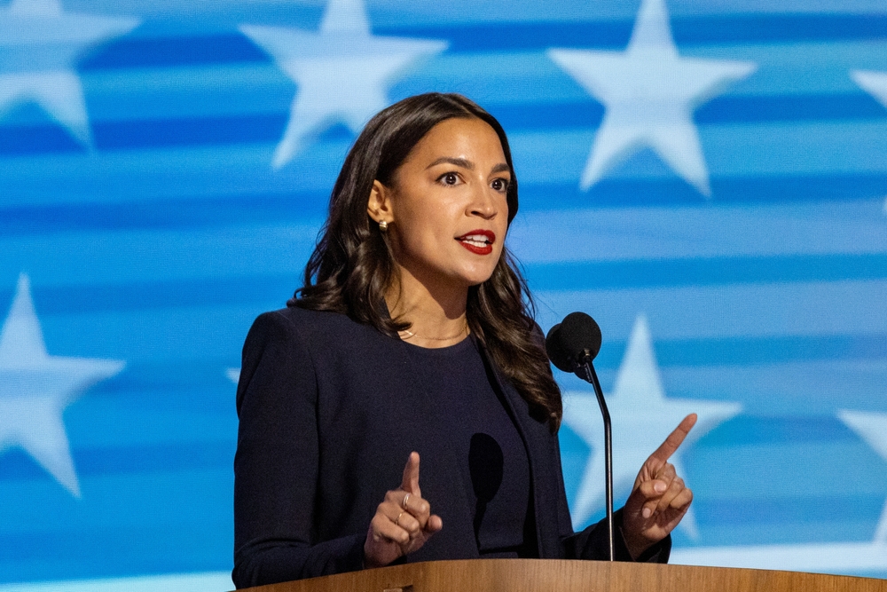 Person speaking at a podium with stars background