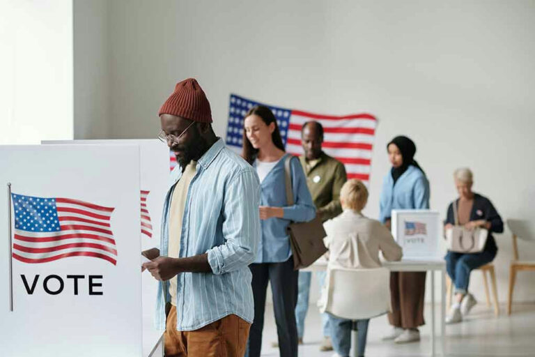 People voting in a polling station with American flags.