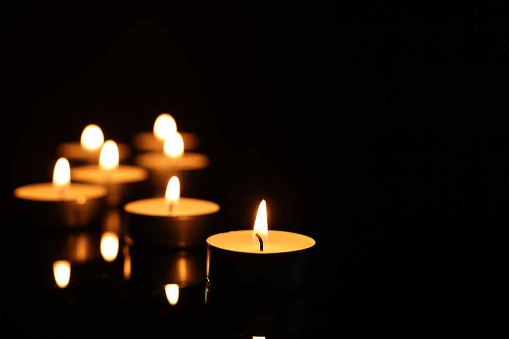 Six lit candles in the dark.