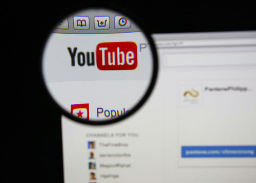 Close-up view of the YouTube website interface through a magnifying glass