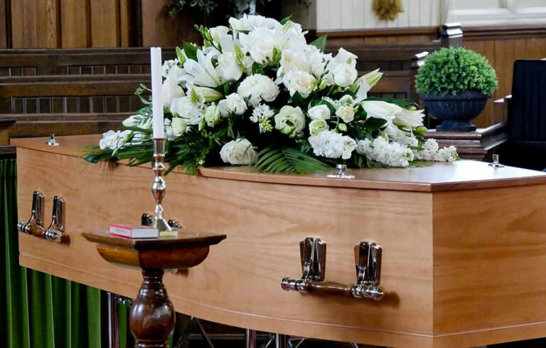 Casket with white flowers in a church.