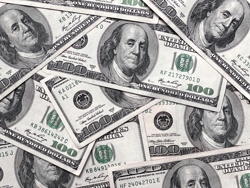 A pile of hundred dollar bills featuring Benjamin Franklin