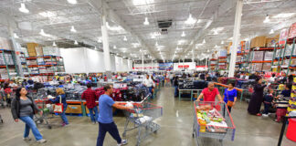 Busy warehouse store with customers shopping and pushing carts