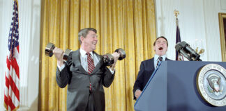 U.S. President Ronald Reagan lifting dumbbells during a press conference with laughter