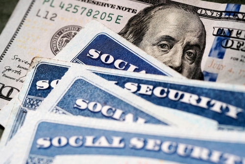 Social security cards and a hundred dollar bill arranged together
